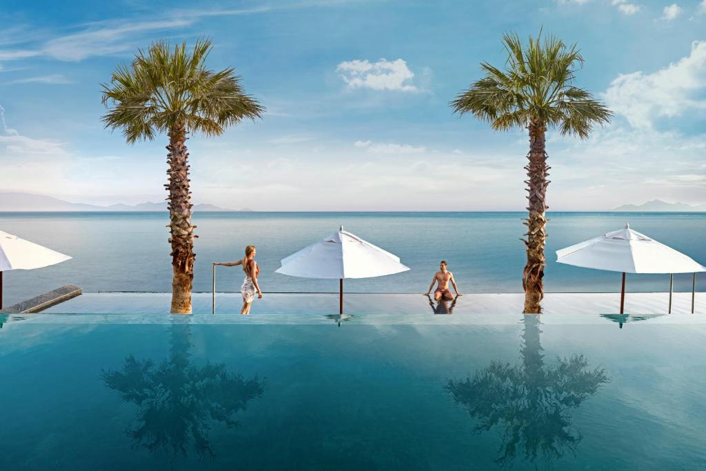 卡尔扎迈纳Mitsis Summer Palace的一座2人游泳池,棕榈树