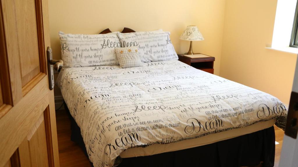 莫纳汉Emy Lake Apartment - near Castle Leslie, Glaslough的一张带白色棉被的床,上面写着