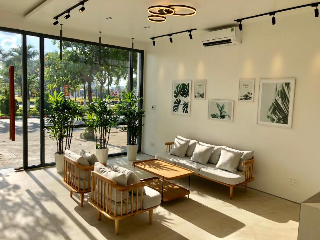 绥和市Coconut Hotel Phú Yên的客厅配有沙发、椅子和桌子
