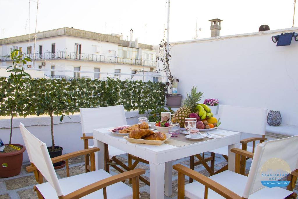 奥斯图尼Casa Filomena的阳台上的白色桌子上摆放着食物