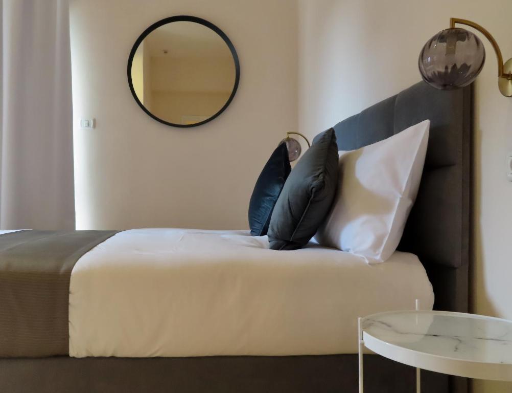耶路撒冷B12 Inn的一间卧室配有带枕头和镜子的床