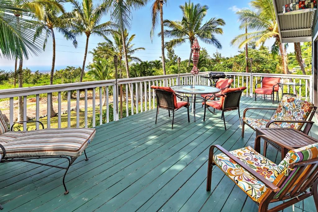 科纳Breezy Kailua-Kona Bungalow with Lanai and Ocean View!的一个带桌椅的甲板和棕榈树