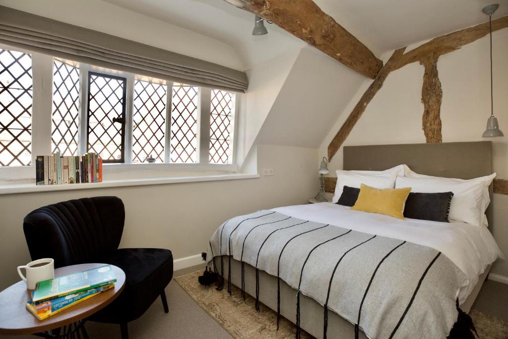 布罗德韦Cotswolds Place - Chancewell的一间卧室配有一张床、一把椅子和窗户。