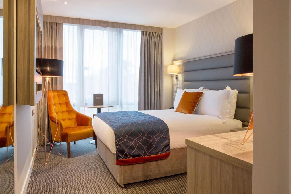 桑特里都柏林机场地铁酒店的酒店客房配有一张床、一把椅子和一张书桌