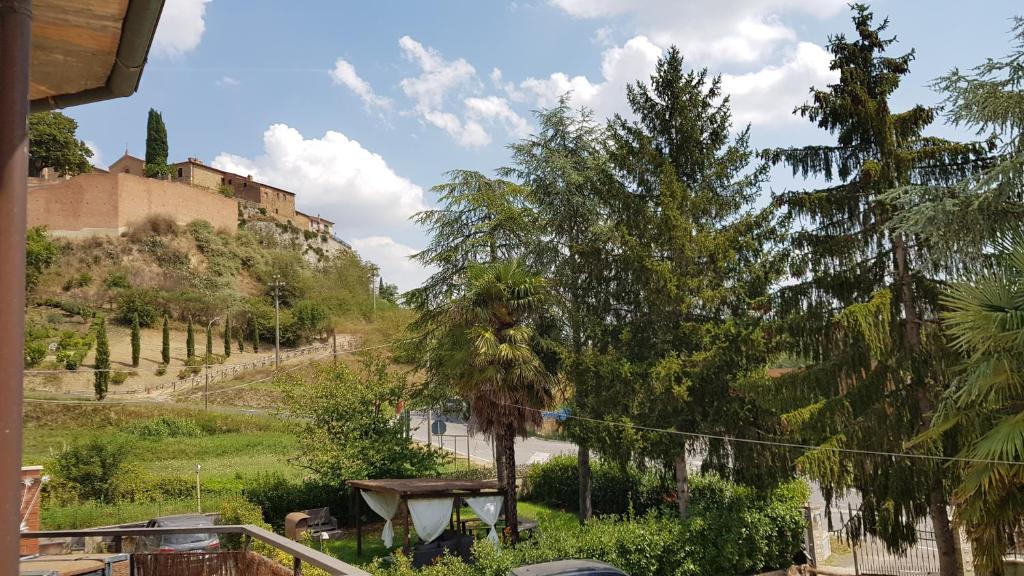 圣焦万尼达索VAL D'ORCIA DELUXE 1 ELEGANTE CASA immersa nel verde con WiFi, giardino e parcheggio的享有树木和建筑的山丘景色