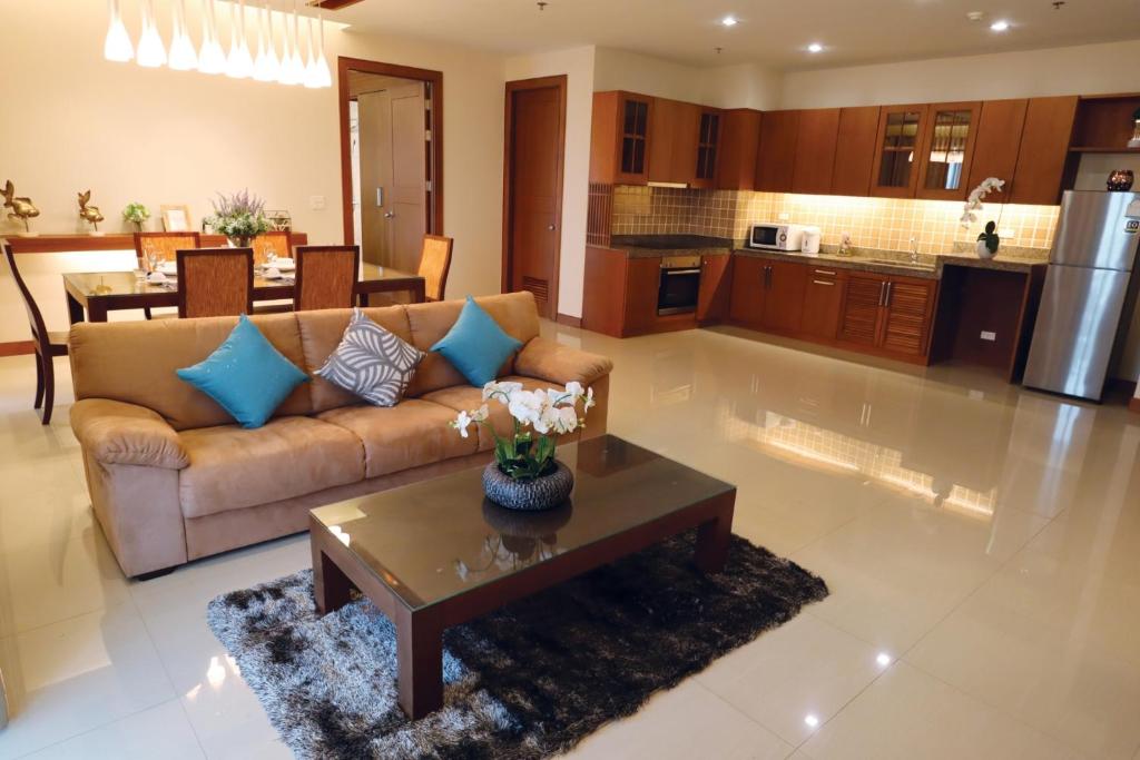 芭堤雅市中心Pattaya City Resort by Harmony的客厅配有沙发和桌子