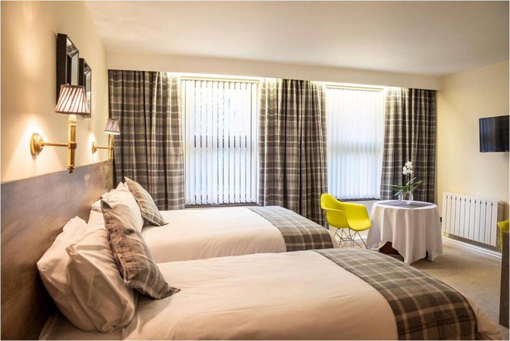 莫斯保罗西特韦尔阿姆斯酒店的酒店客房设有两张床和一张桌子。