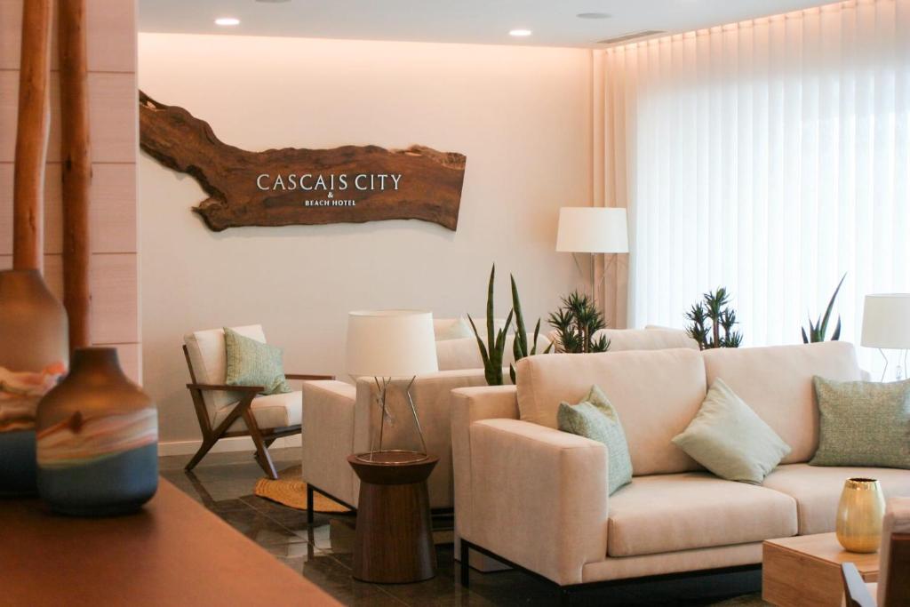 卡斯卡伊斯Cascais City & Beach Hotel的客厅配有沙发和墙上的标志