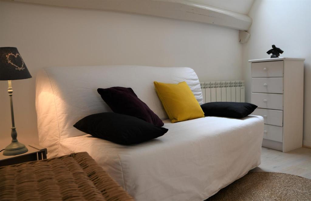 圣艾尼昂La Petite Maison d'à Côté的一张白色的床,上面有四个枕头