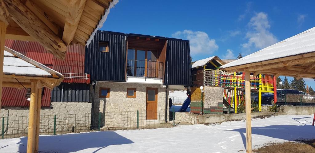 特拉夫尼克Apartman za dvoje的一座带雪地游乐场的建筑