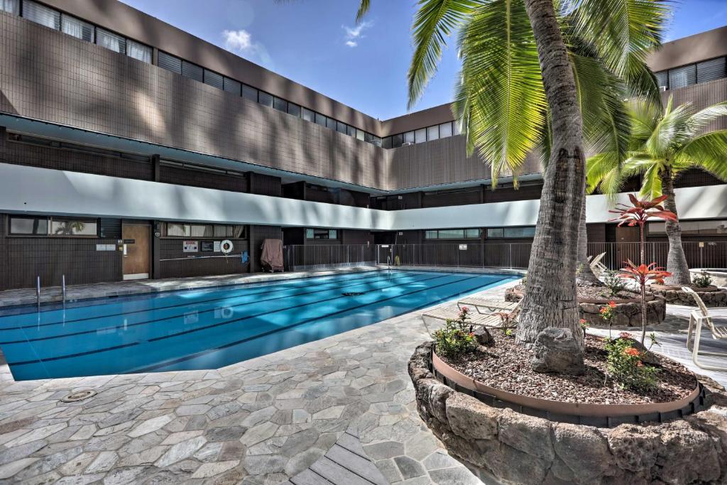 檀香山Downtown Honolulu Suite Near Ala Moana Beach!的一座建筑前的游泳池,里面种着棕榈树