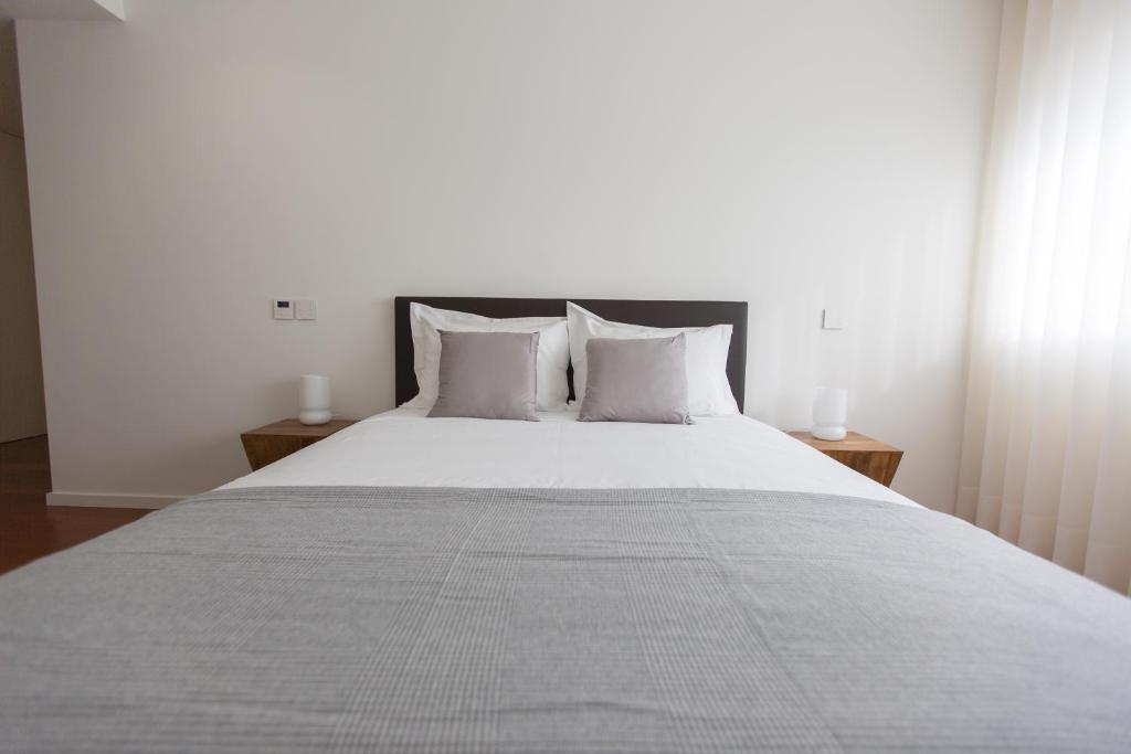 布拉加Braga Luxury Residence 3854的卧室配有一张带白色床单和枕头的大床。
