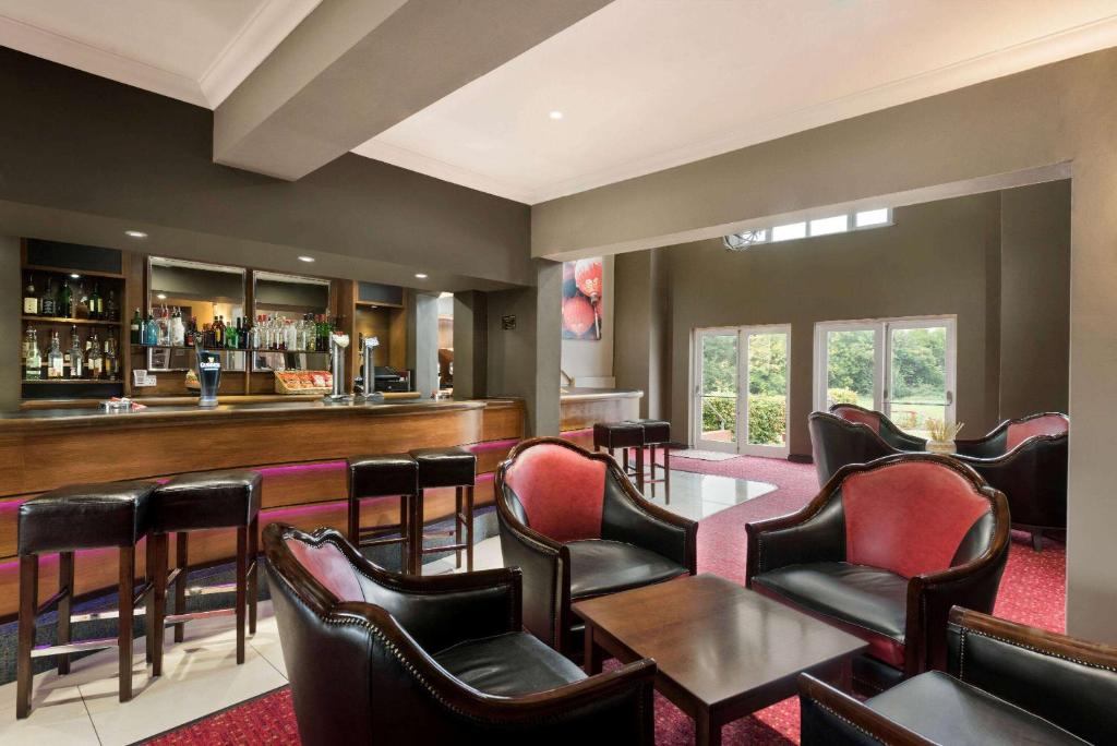 沃里克Riverside Hotel的餐厅内的酒吧配有椅子和柜台