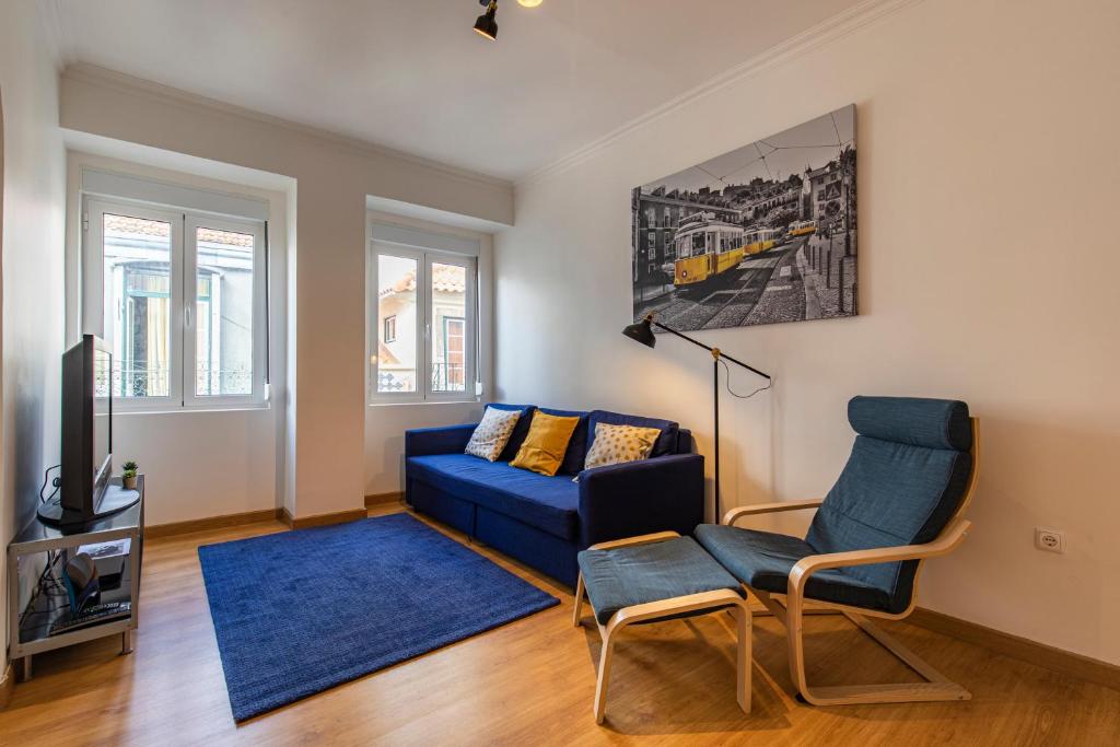 里斯本3 bedroom apt near Av. Liberdade的客厅配有蓝色的沙发和电视