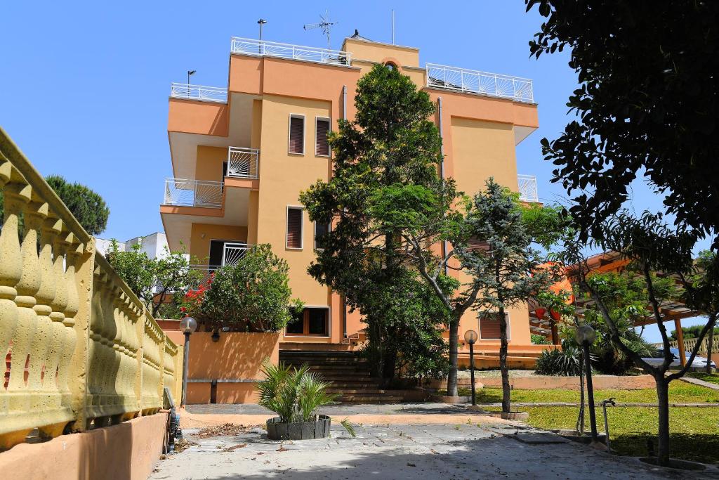 普尔萨诺B&B Il Canto Del Mare的一座黄色的建筑,前面有楼梯和树木