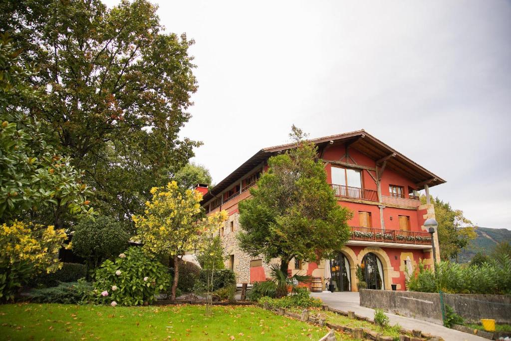欧阿提兹乌萨太吉塔酒店的一座种有树木和院子的大型红色房子