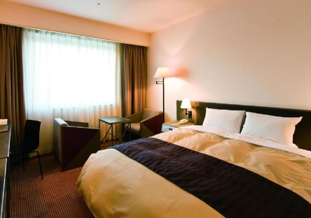 大垣Ogaki Forum Hotel / Vacation STAY 72180的酒店客房设有床和窗户。