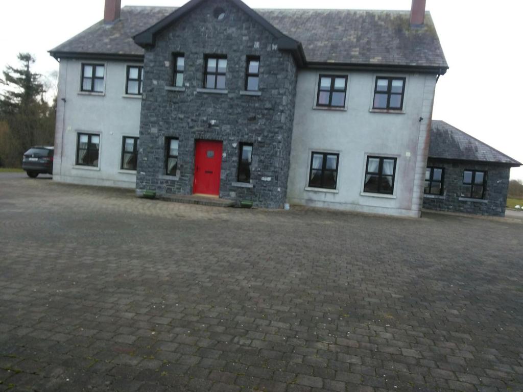 巴利纳斯洛Riverview Country House的一间设有红色门的大型白色房屋