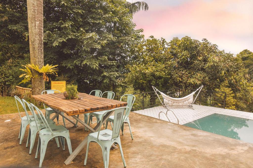 茂物Villa Jenis By The Villas 100的一张木桌和椅子,旁边是游泳池