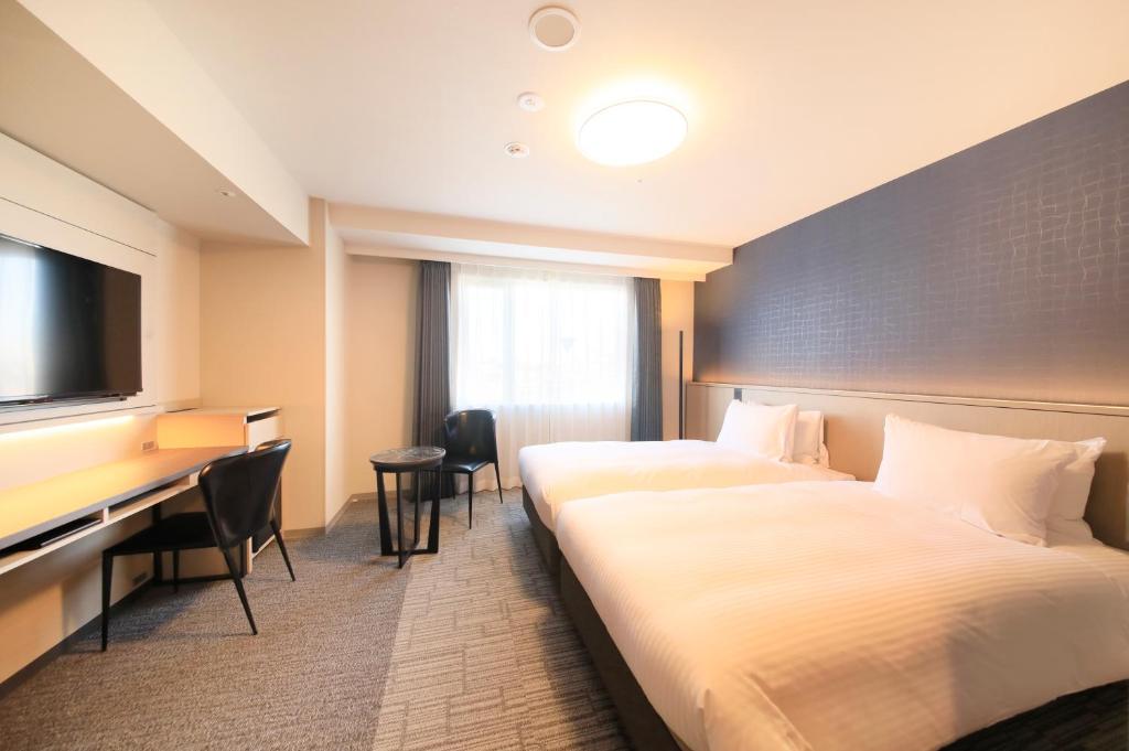 横滨横滨站前里士满酒店(Richmond Hotel Yokohama Ekimae)的酒店客房配有两张床和一张书桌