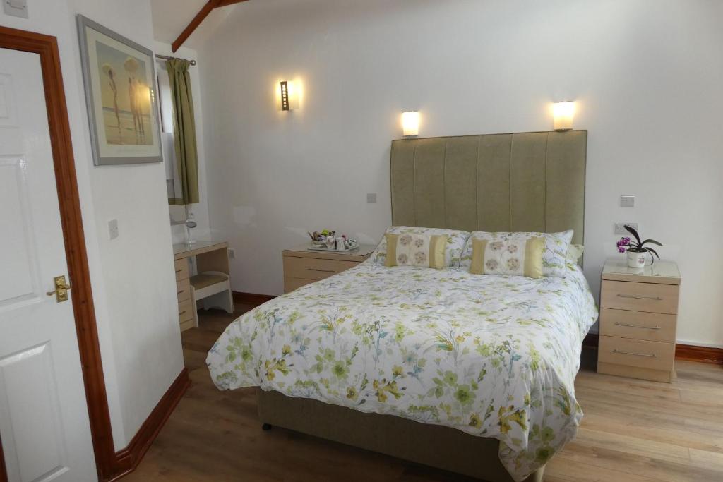 劳斯West View Farm的一间卧室配有一张大床和绿色床头板