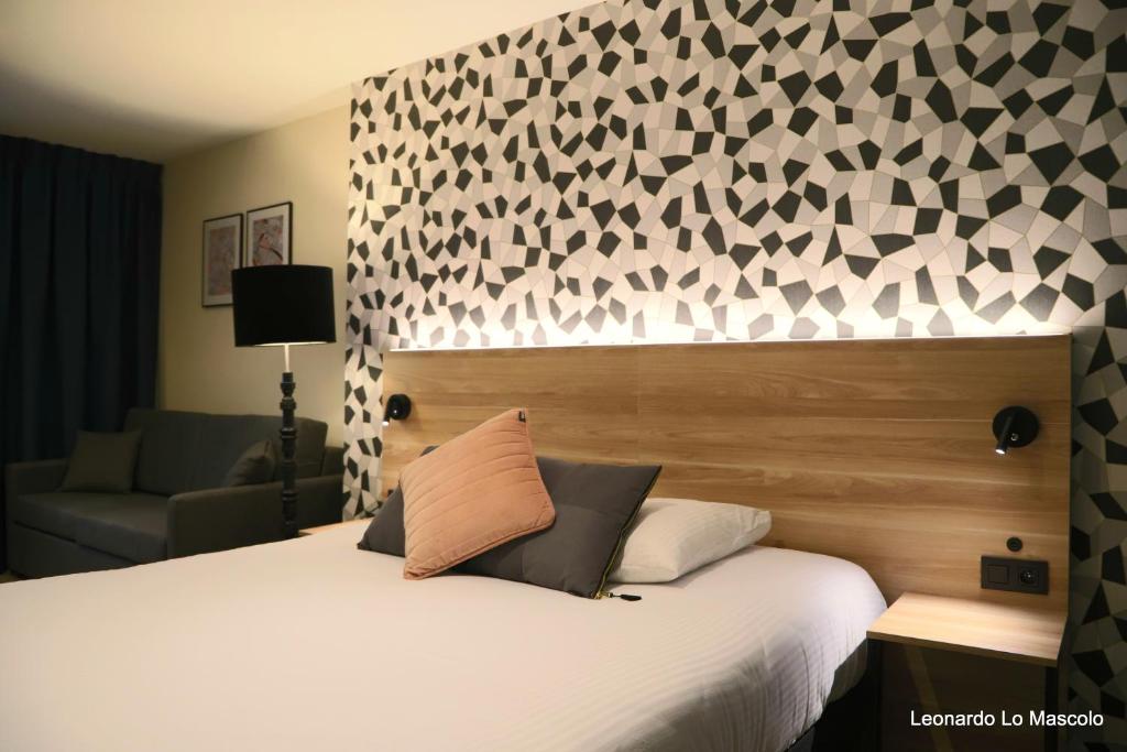 列日Hôtel de l'Univers Liège的一间卧室配有一张大床、白色床罩和墙壁