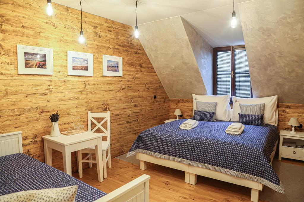 Soběsuky昂格斯法姆旅馆的一间卧室设有两张床和木墙