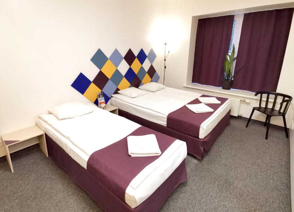 里加马赛克酒店的酒店客房,配有两张床和椅子