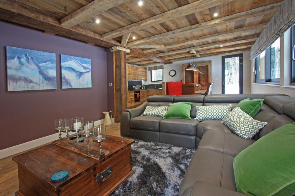 夏蒙尼-勃朗峰Chalet des Amis appt 1 - Chamonix All Year的客厅配有沙发和桌子