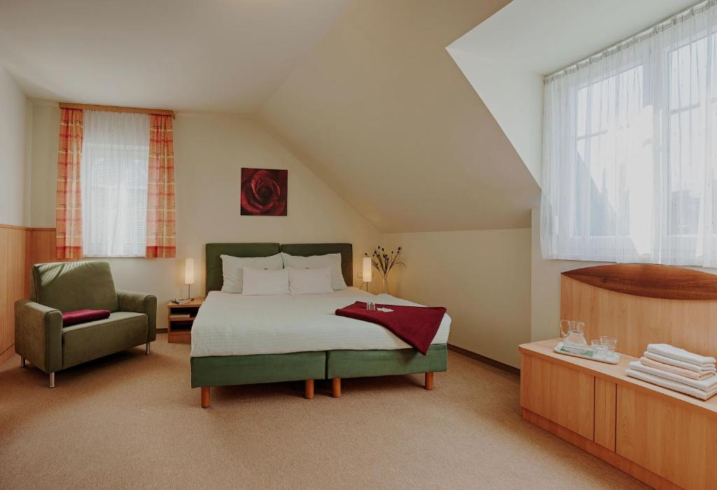 维也纳卡斯帕膳食公寓酒店的一间卧室配有一张床和一把椅子