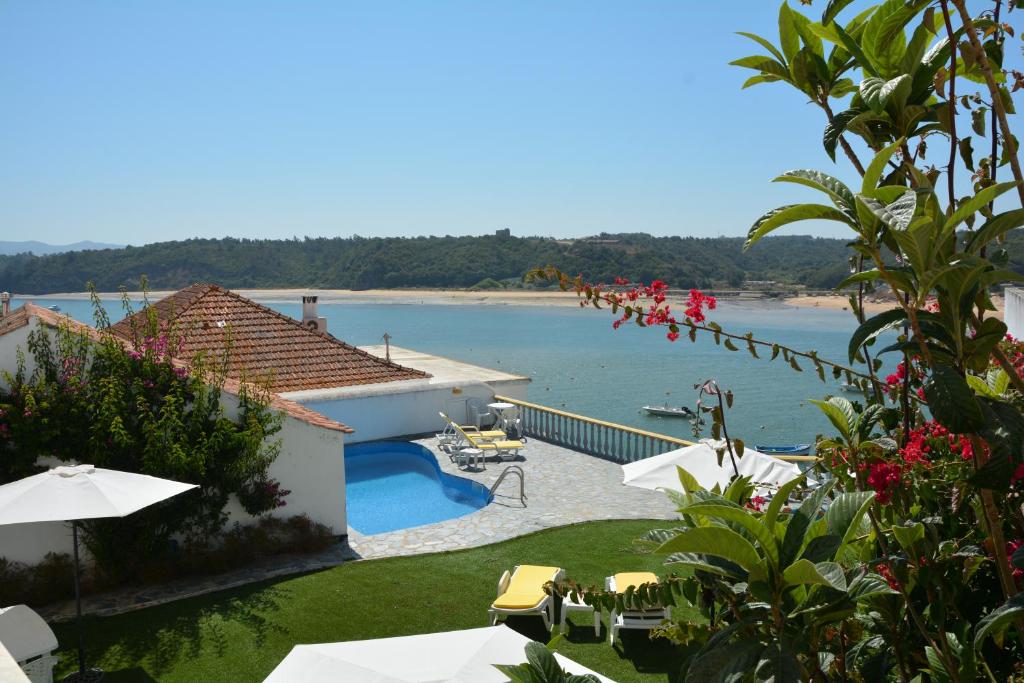 米尔芳提斯城Apartamentos Cintra do Vale的享有水景的带游泳池的度假酒店