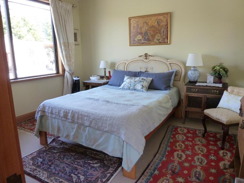 里士满Redwood Valley B & B的一间卧室配有一张带蓝色枕头的大床