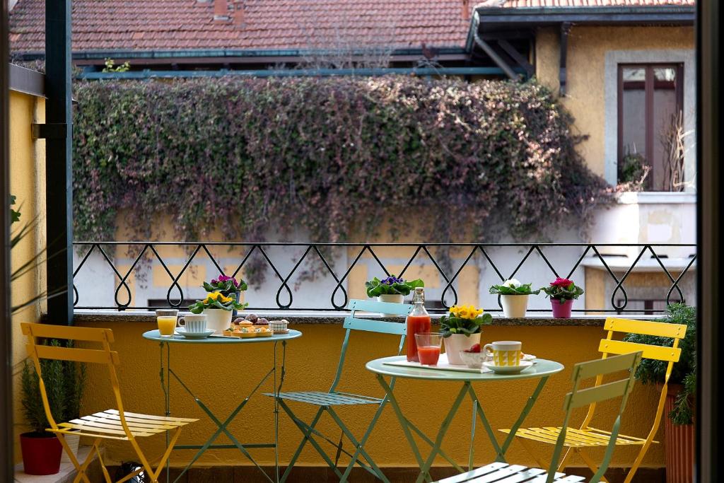 米兰B&B La Terrazza di Barbara的两把桌子和椅子坐在开满鲜花的庭院里