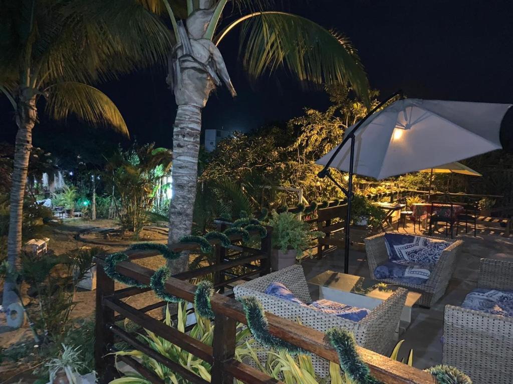 索里托斯Villa Mistika的一个带椅子和遮阳伞的庭院,以及棕榈树