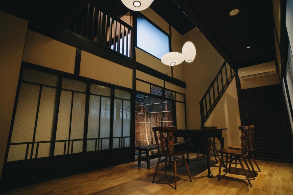 京都七条みやび Nanajo Miyabi Inn的一间带桌椅和窗户的用餐室