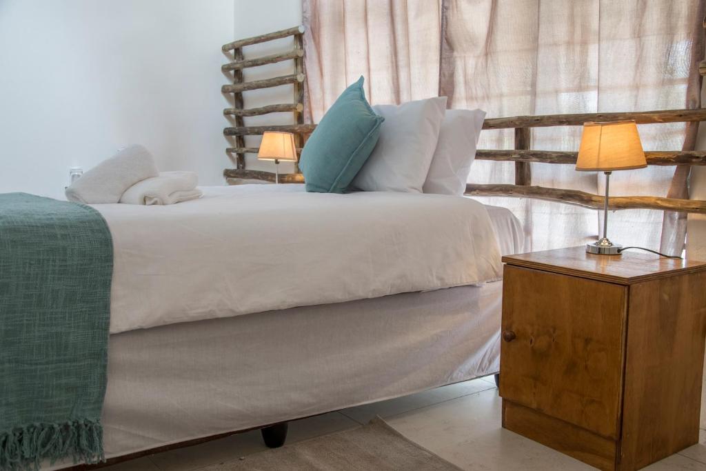 卡萨内Leeville Guesthouse的一间卧室配有一张带两张台灯的床。