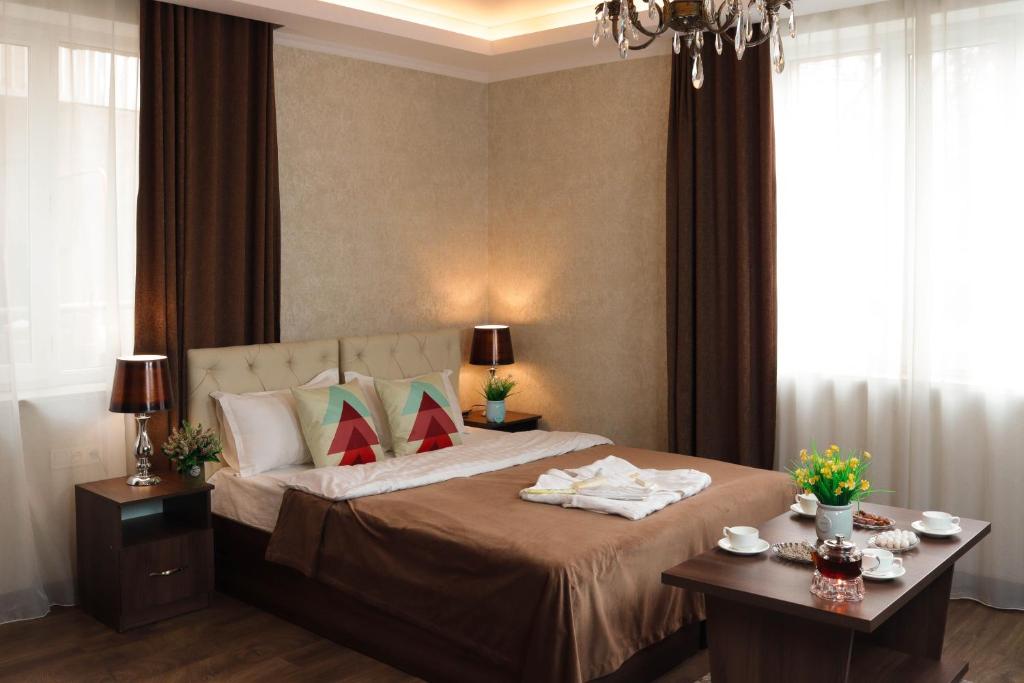 比什凯克德玛尔酒店的一间卧室配有一张大床和两张桌子