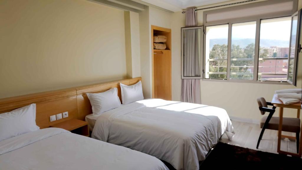 贝尼迈拉勒Hotel Golden Flora的酒店客房设有两张床和窗户。