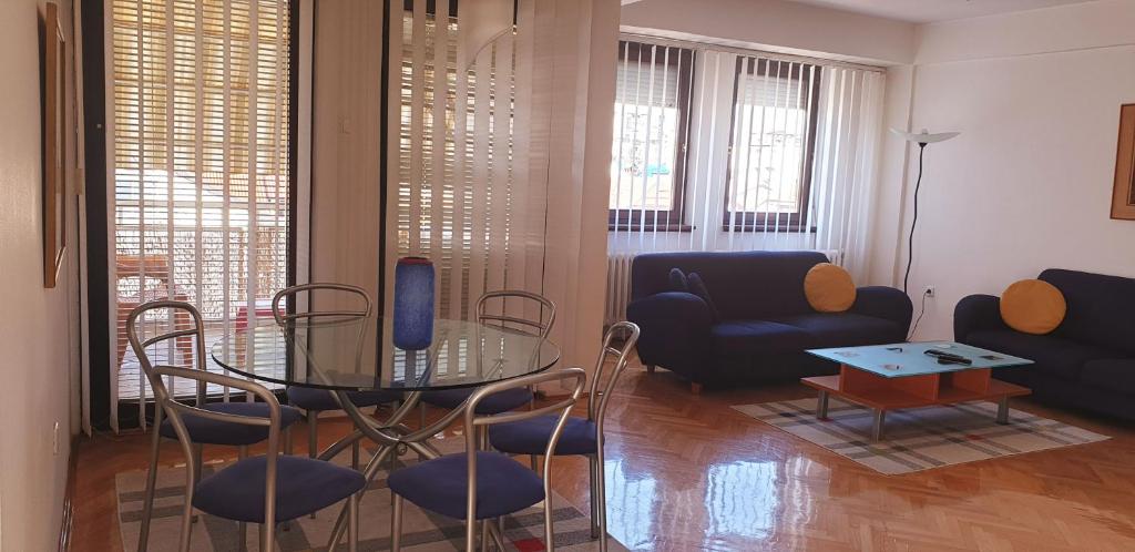 斯科普里Spectacular apartment in Skopje, City Mall area的客厅配有玻璃桌和椅子