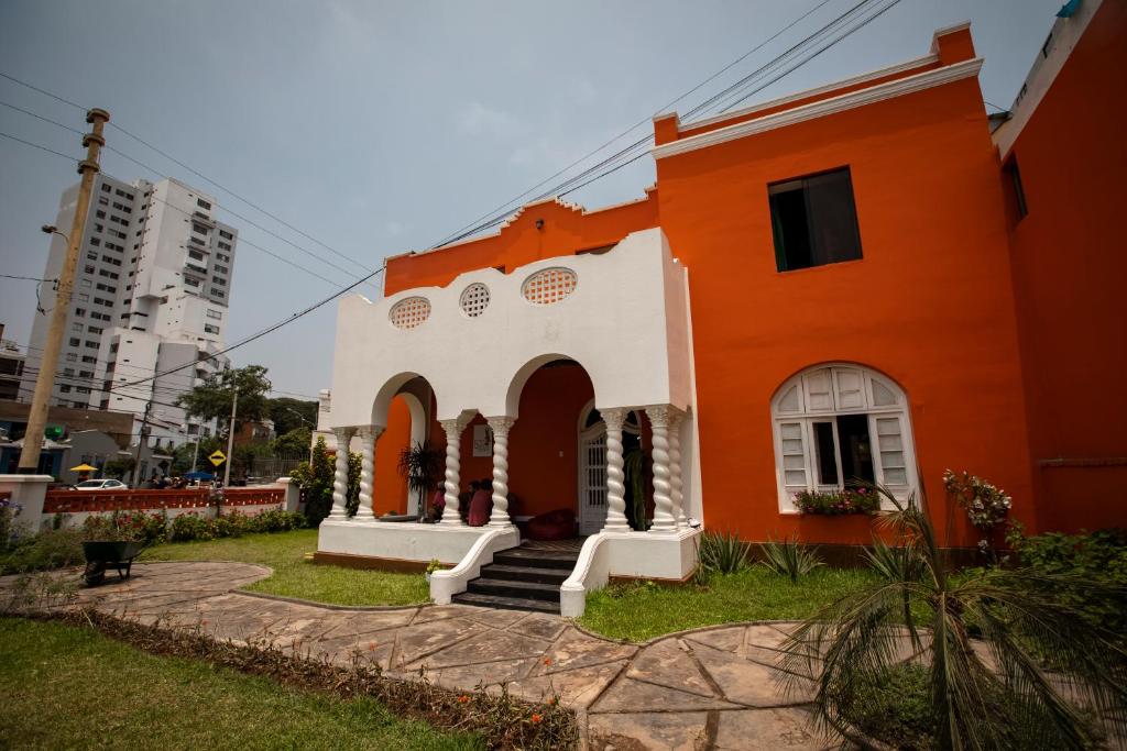 利马Great Partners hostel的一座橙色和白色的建筑,在庭院里设有楼梯