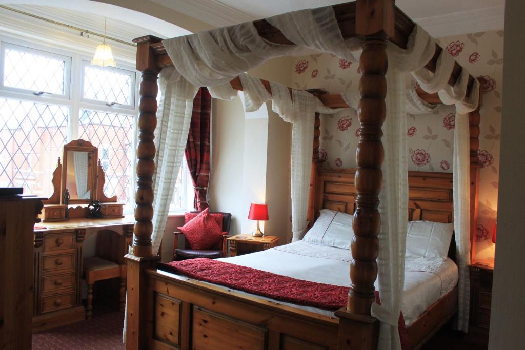 布里德灵顿贝尔蒙特旅馆的一间卧室配有一张天蓬床和一张书桌