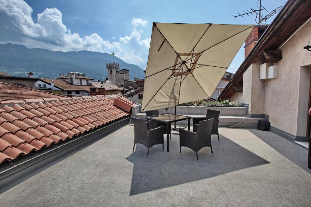 特伦托艾尔伯格阿卡戴米亚酒店的庭院配有桌椅和遮阳伞。
