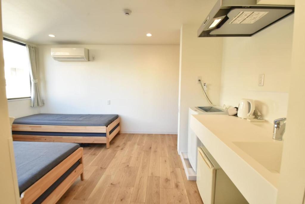 东京Enzo Tokyo的小房间设有两张床和盥洗盆