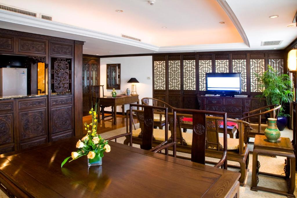 青岛青岛颐中皇冠假日酒店的客厅配有桌椅和电视。