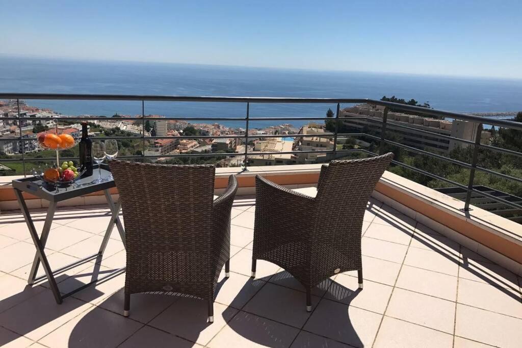 塞辛布拉Luxus Ferienhaus Casa Paraiso的阳台配有两把椅子和一张桌子,享有海景。