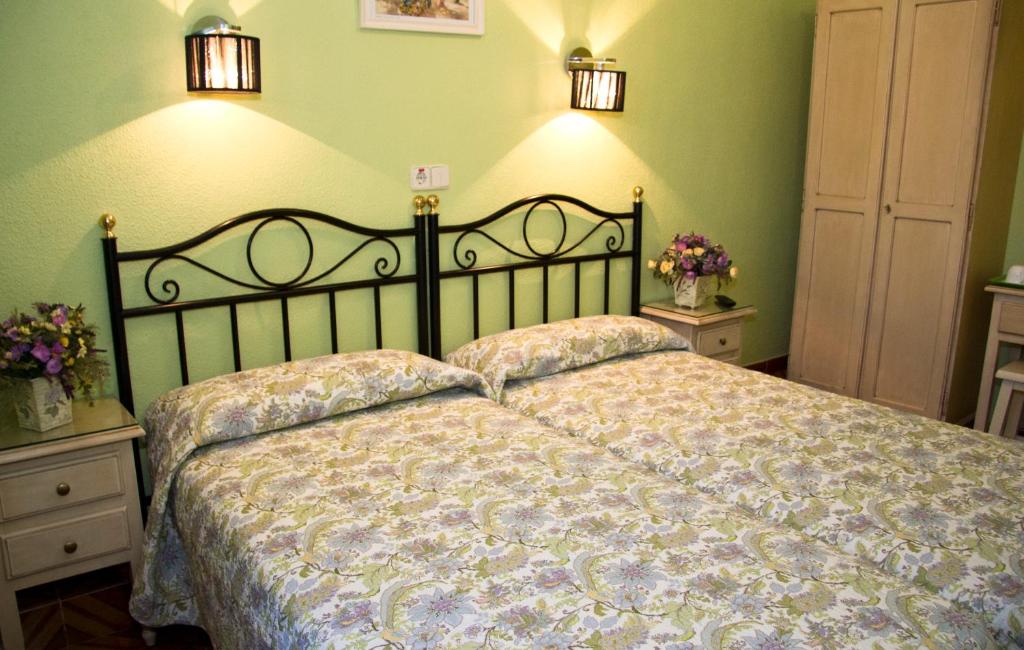 马德里洛斯阿尔帕斯酒店的卧室内的一张床位,拥有绿色的墙壁和灯光