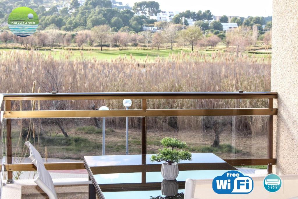 拉皮内达Playa y golf La Pineda的阳台配有桌椅,享有田野美景。