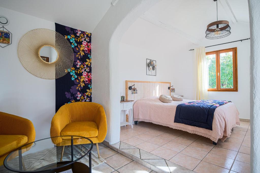 Puyricard阿罗希杜宾酒店的一间卧室配有一张床、一把椅子和一张桌子