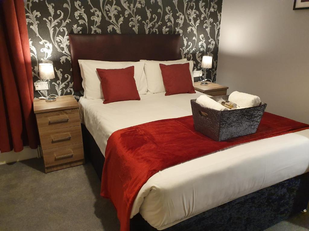 绍斯波特The Braemar Southport的一间卧室配有一张带红色枕头的大床