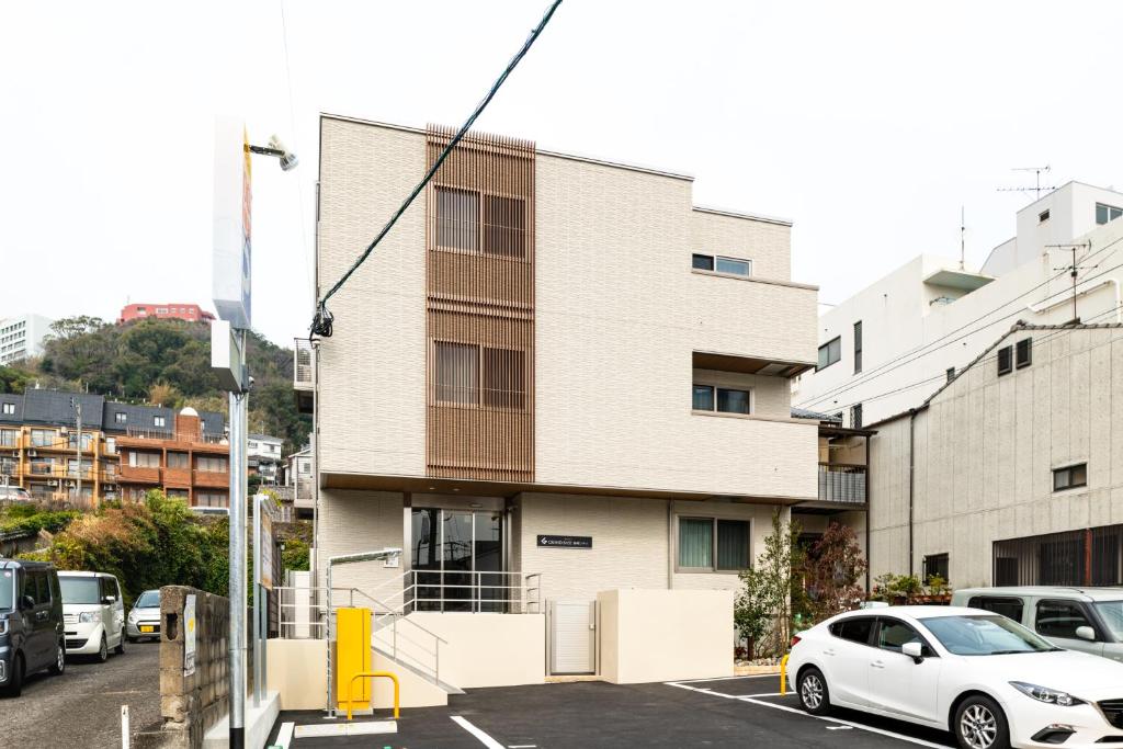 长崎GRAND BASE Nagasaki City的停在大楼前停车场的白色汽车
